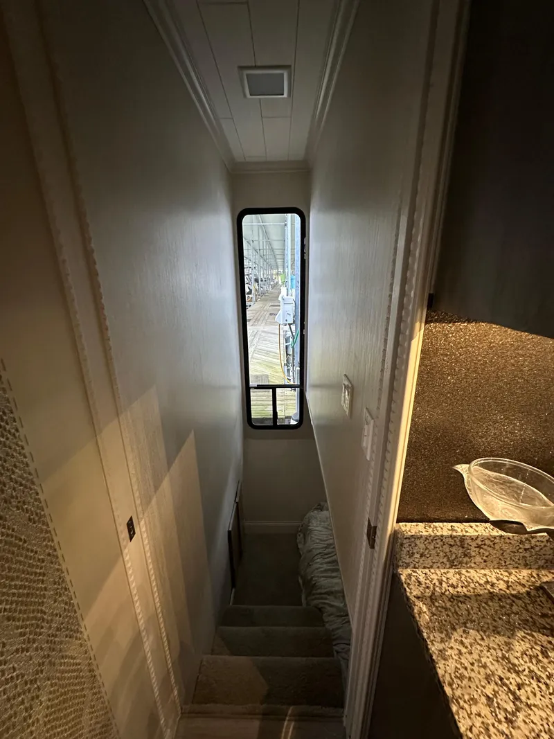 Slide: The Image of Narrow hallway in a 1991 Sumerset 14x60 houseboat with stairs and window. - 6