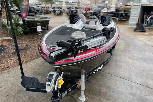 Slide: The Image of 2016 Nitro Z21 boat on trailer, parked outdoors, featuring dual seats and fishing equipment. - 4