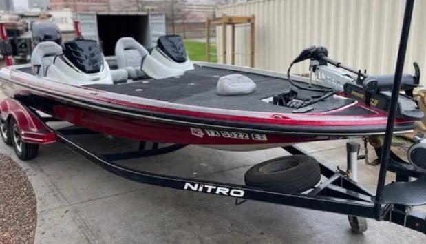 Slide: The Image of 2016 Nitro Z21 boat on trailer, red and black, parked outdoors. - 5
