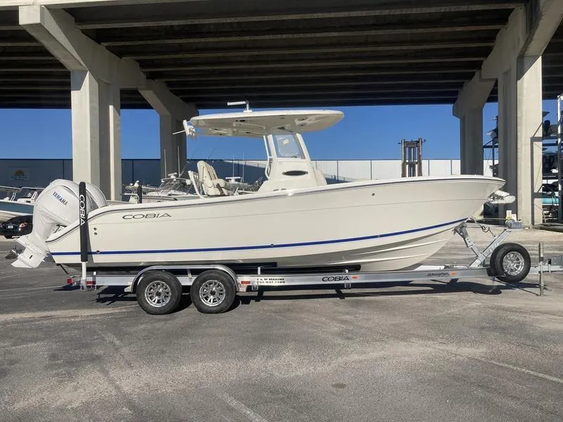 Slide: The Image of 2024 Cobia 262 CC boat on trailer under bridge, side view. - 5