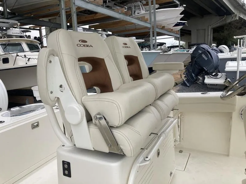 Slide: The Image of 2024 Cobia 262 CC boat with dual cushioned seats and sleek design. - 9