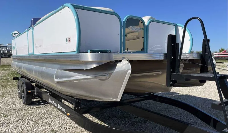 Slide: The Image of 2022 Aloha Pontoon Mahalo 250 on trailer, side view under clear blue sky. - 3