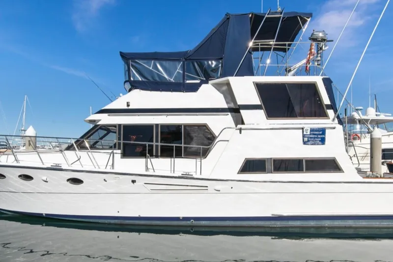 Slide: The Image of 1989 Lien Hwa Vitesse Yachtfisher, white exterior, docked in marina under clear blue sky. - 3