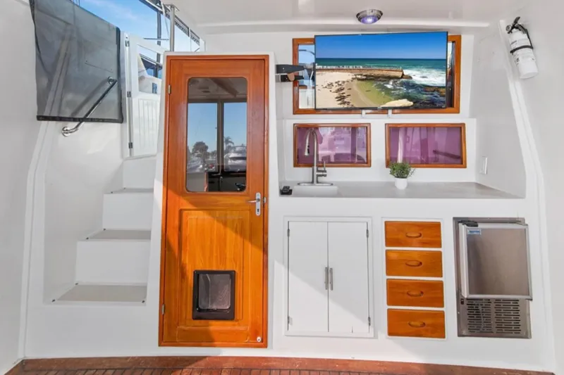Slide: The Image of 1989 Lien Hwa Vitesse Yachtfisher interior with wooden door, kitchenette, and TV. - 31