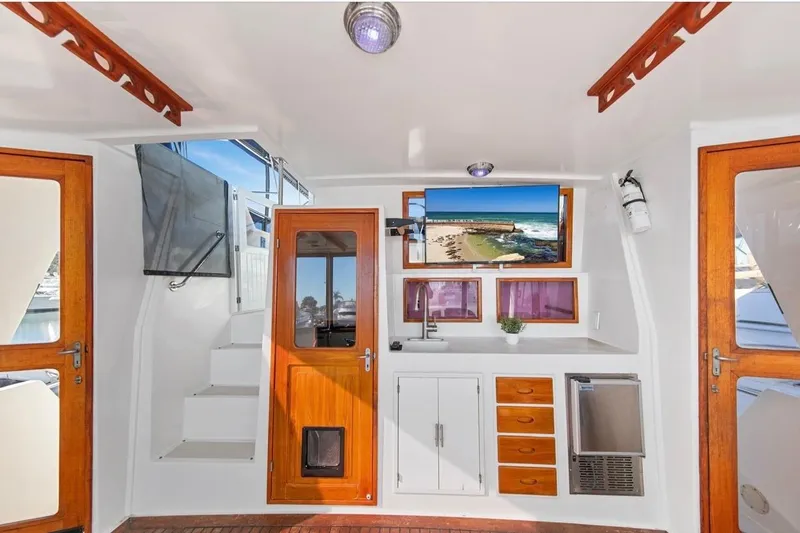 Slide: The Image of 1989 Lien Hwa Vitesse Yachtfisher interior with wooden doors, white cabinetry, and a mounted TV. - 33