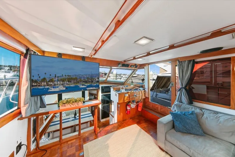 Slide: The Image of 1989 Lien Hwa Vitesse Yachtfisher interior with helm, sofa, and large window views. - 9