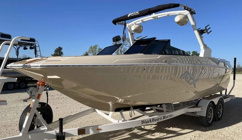 Slide: The Image of 2024 ATX Surf Boats 24 Type-S on trailer, sleek design, outdoor setting. - 2