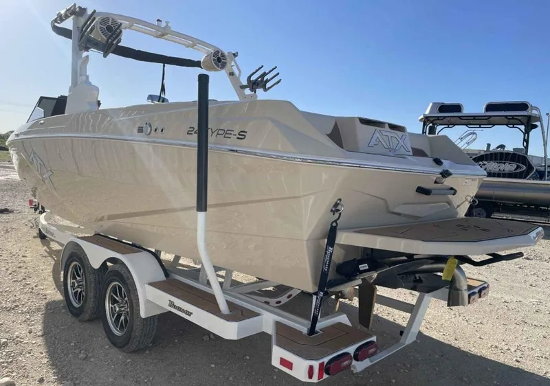 Slide: The Image of 2024 ATX Surf Boats 24 Type-S on trailer, rear view, beige color, outdoor setting. - 3