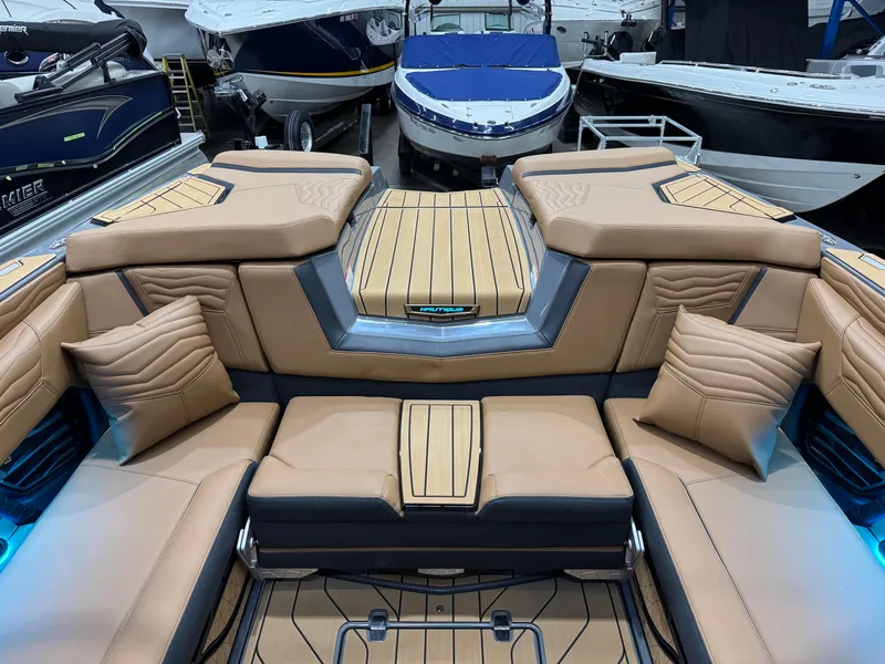 Slide: The Image of 2025 Nautique Super Air Nautique G23 interior with tan leather seating and modern design. - 10