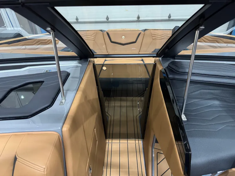 Slide: The Image of 2025 Nautique Super Air Nautique G23 interior with tan and black upholstery. - 18