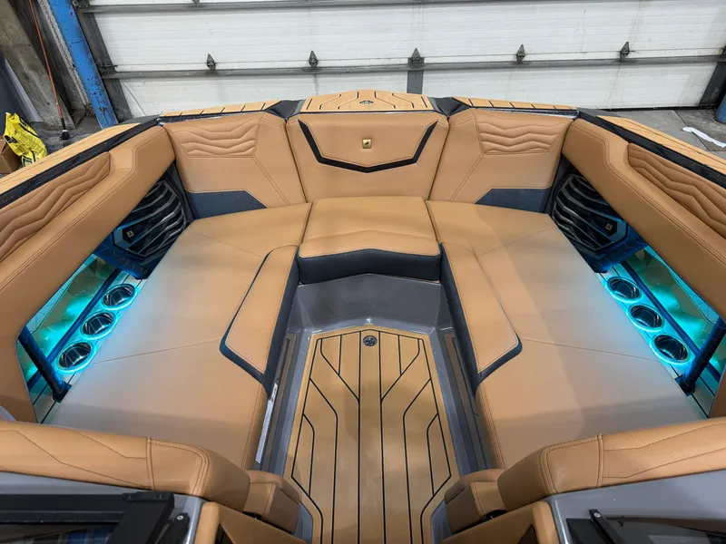 Slide: The Image of 2025 Nautique Super Air Nautique G23 interior with tan leather seats and blue LED lighting. - 22