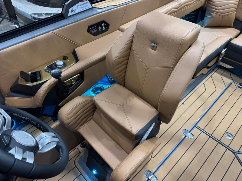 Slide: The Image of 2025 Nautique Super Air Nautique G23 interior with tan leather seating and modern controls. - 26
