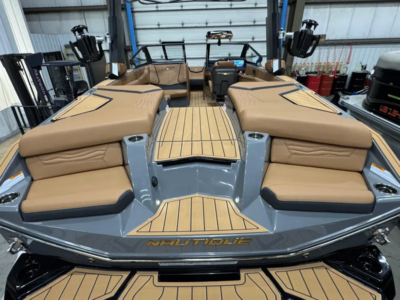 Slide: The Image of 2025 Nautique Super Air Nautique G23 boat interior with tan seating and sleek design. - 6