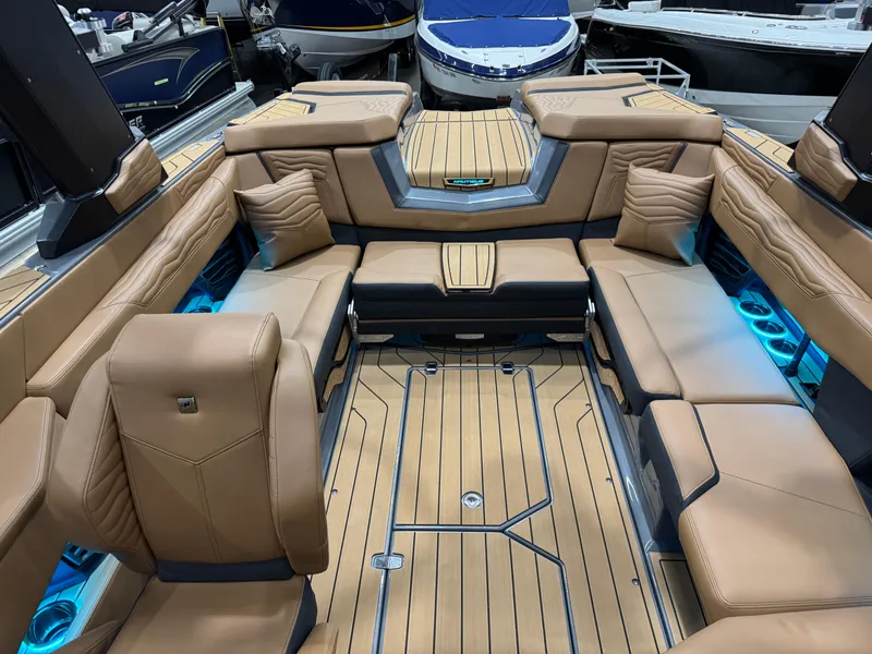 Slide: The Image of 2025 Nautique Super Air Nautique G23 interior with tan seating and blue LED lighting. - 9