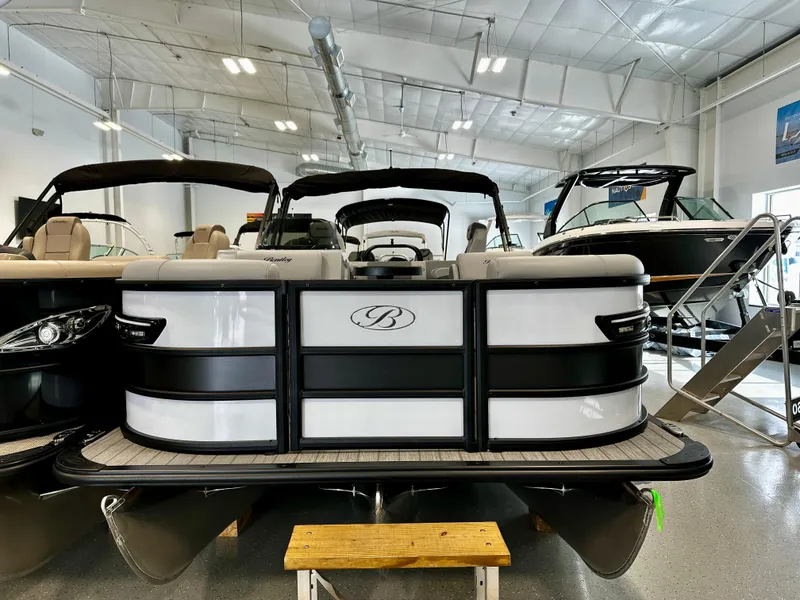 Slide: The Image of 2025 Bentley Pontoons Elite 223 Swingback in showroom, front view, sleek design. - 2