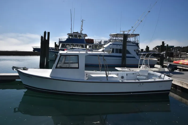 The Image of Custom 2011 Downeast boat docked in a marina, with larger vessels in the background. - 1