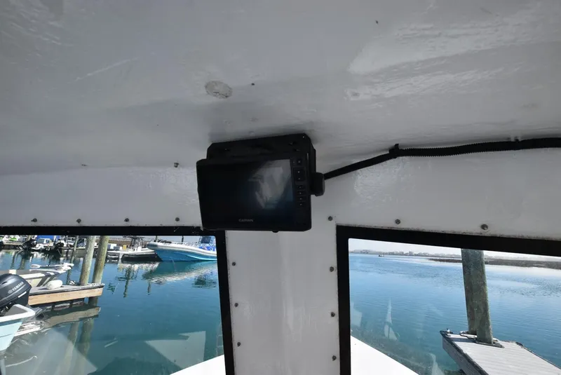 Slide: The Image of Interior of a 2011 Custom Downeast boat with a mounted monitor, overlooking a marina. - 11