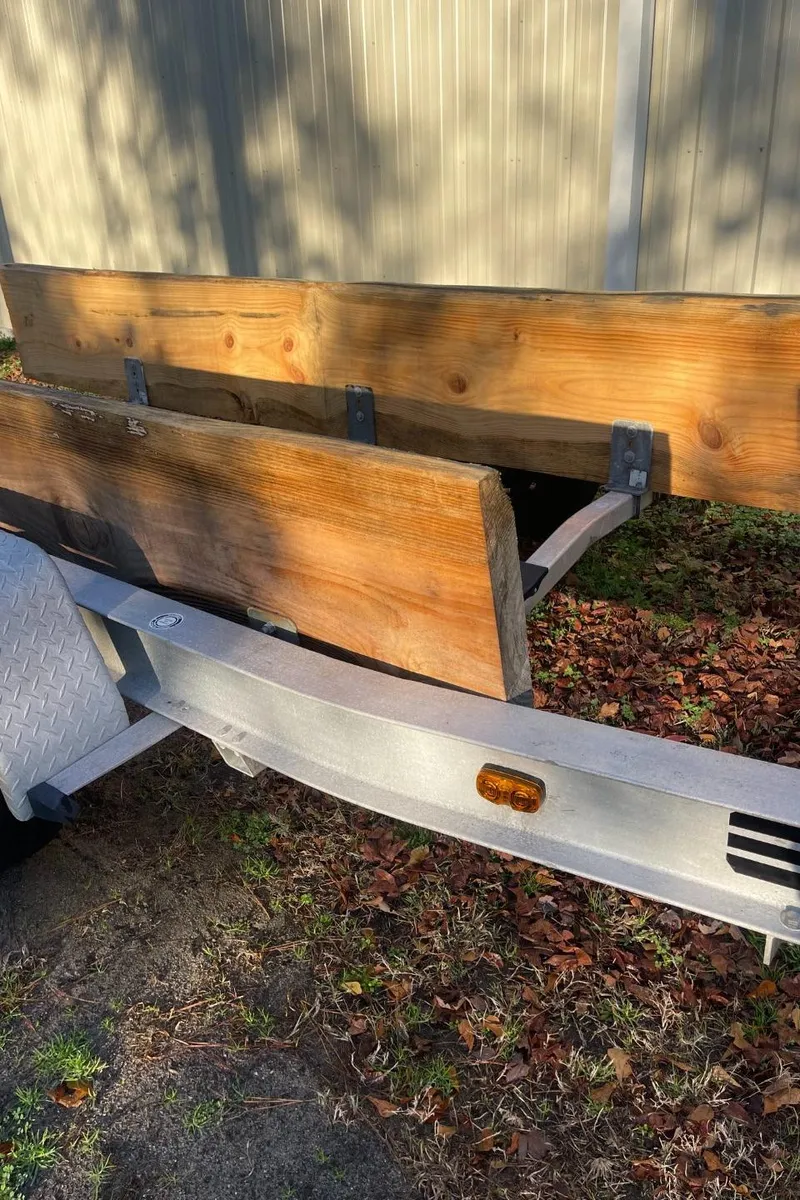 Slide: The Image of 2011 Custom Downeast trailer with wooden side panels, parked on grass. - 16