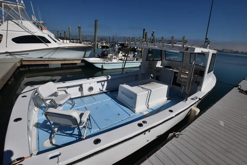 Slide: The Image of Custom 2011 Downeast boat docked at marina, featuring open deck and seating. - 3