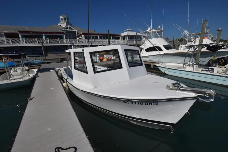 Slide: The Image of 2011 Custom Downeast boat docked at marina, clear sky, surrounded by other boats. - 4