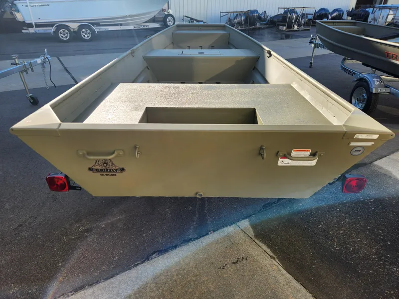 Slide: The Image of 2025 Tracker 1542 LW boat, rear view, parked on trailer in outdoor setting. - 5