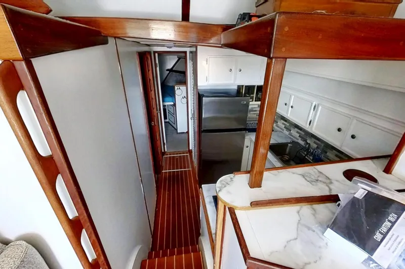 Slide: The Image of Interior of a 1973 Viking 40 yacht, featuring restored wood and modern kitchen amenities. - 23