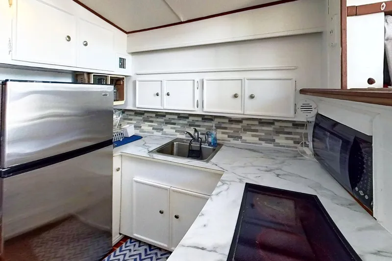 Slide: The Image of 1973 Viking kitchen restoration with modern appliances, marble countertops, and mosaic backsplash. - 24