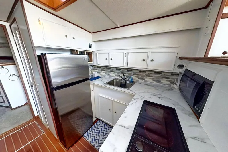 Slide: The Image of Restored 1973 Viking kitchen with modern appliances, marble countertops, and stylish backsplash. - 25