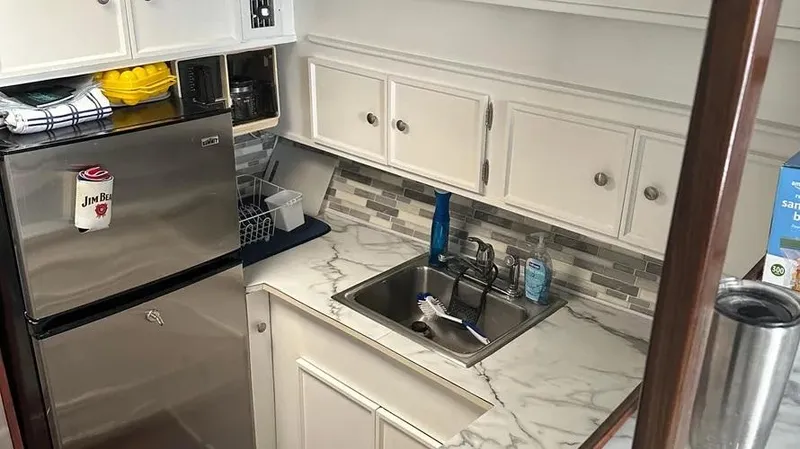 Slide: The Image of Compact kitchen in a 1973 Viking boat with stainless steel appliances and marble countertops. - 26