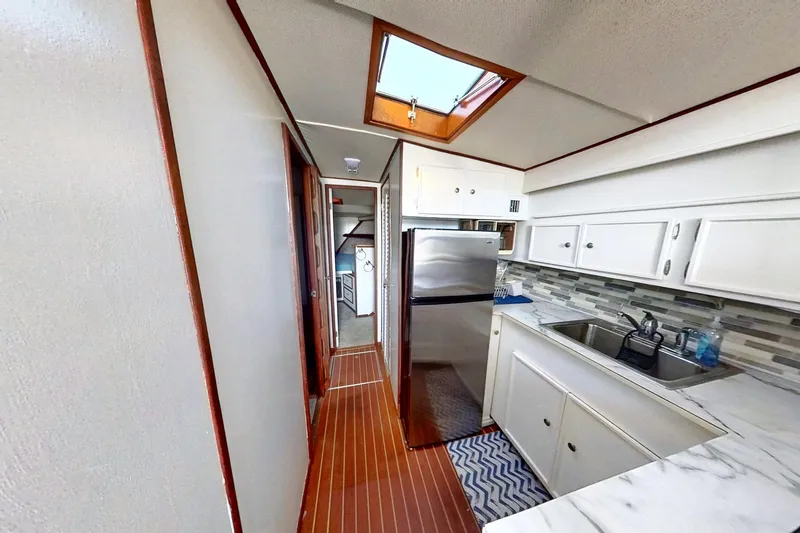 Slide: The Image of 1973 Viking 40 yacht interior with modern kitchen, white cabinets, and wood flooring. - 28