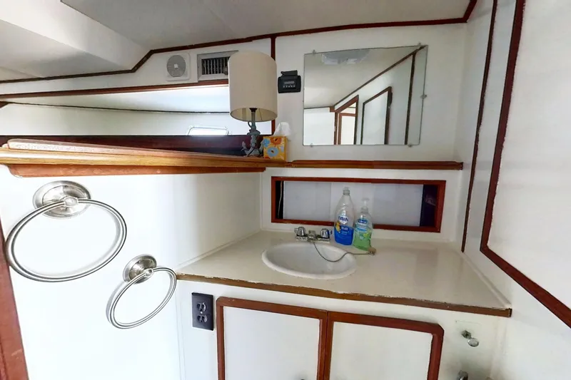 Slide: The Image of 1973 Viking 40 yacht bathroom with sink, mirror, and wooden accents. - 31