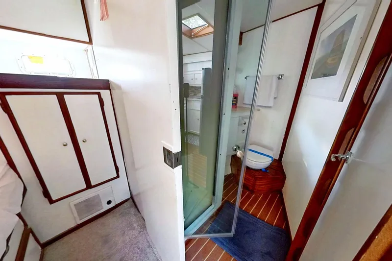 Slide: The Image of Restored 1973 Viking boat interior with bathroom, wooden flooring, and white cabinetry. - 38