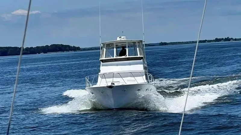 Slide: The Image of A 1973 Viking boat cruising on open water, creating a wake behind it. - 4