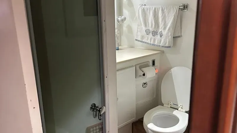 Slide: The Image of Bathroom interior of a 1973 Viking model boat, featuring a toilet and towel rack. - 40