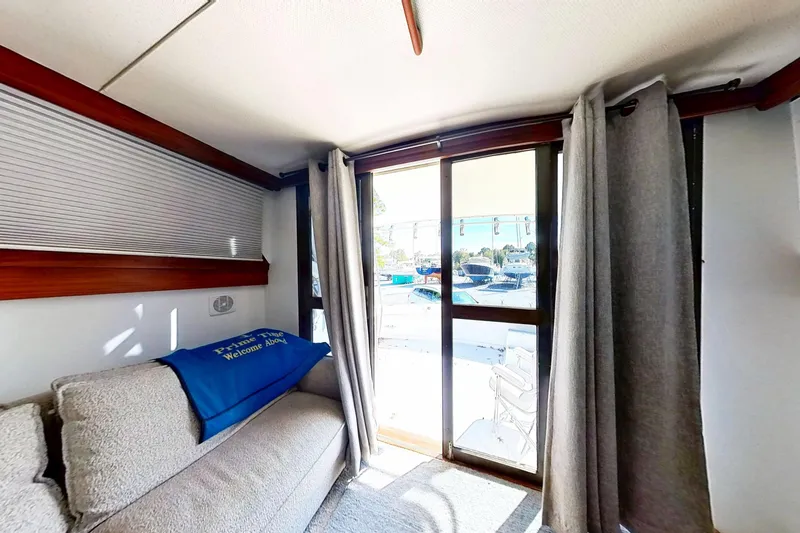 Slide: The Image of Interior of 1973 Viking 40, featuring cozy seating and marina view through sliding doors. - 42