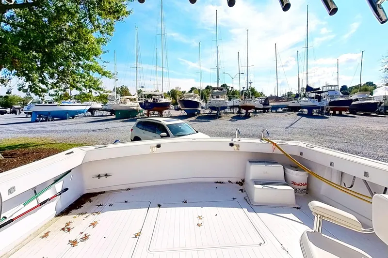 Slide: The Image of 1973 Viking boat in marina, surrounded by parked boats and trees under a clear sky. - 43