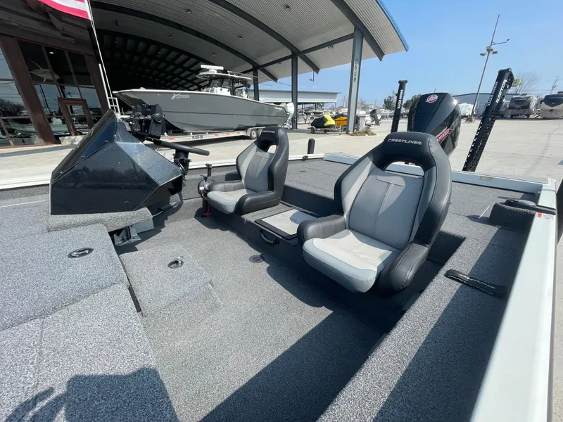 Slide: The Image of 2021 Crestliner 21 MX boat interior with two seats, modern design, and outdoor setting. - 5