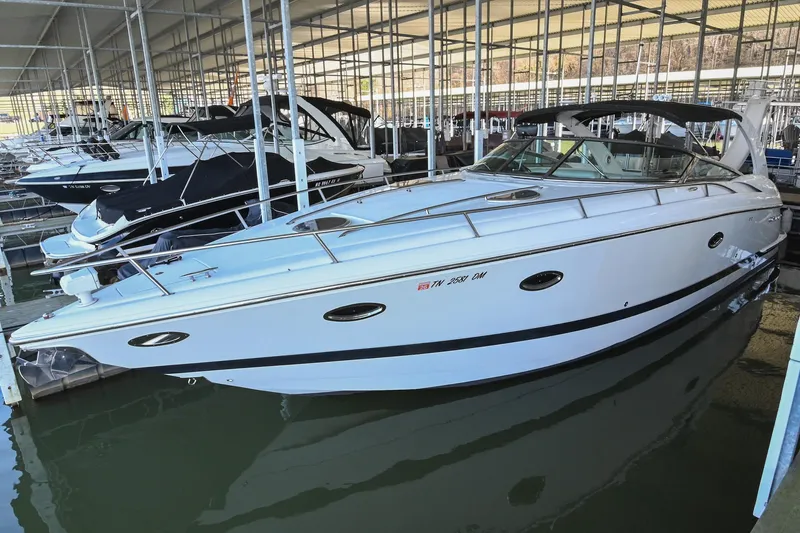 Slide: The Image of 2004 Cobalt 360 boat docked in a marina, featuring sleek white design and spacious deck. - 13