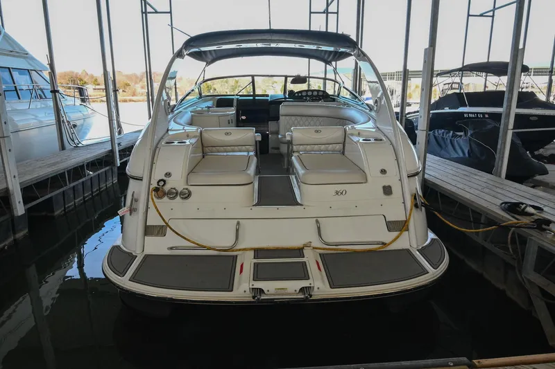 Slide: The Image of 2004 Cobalt 360 boat docked in a marina, rear view showing seating and deck. - 17