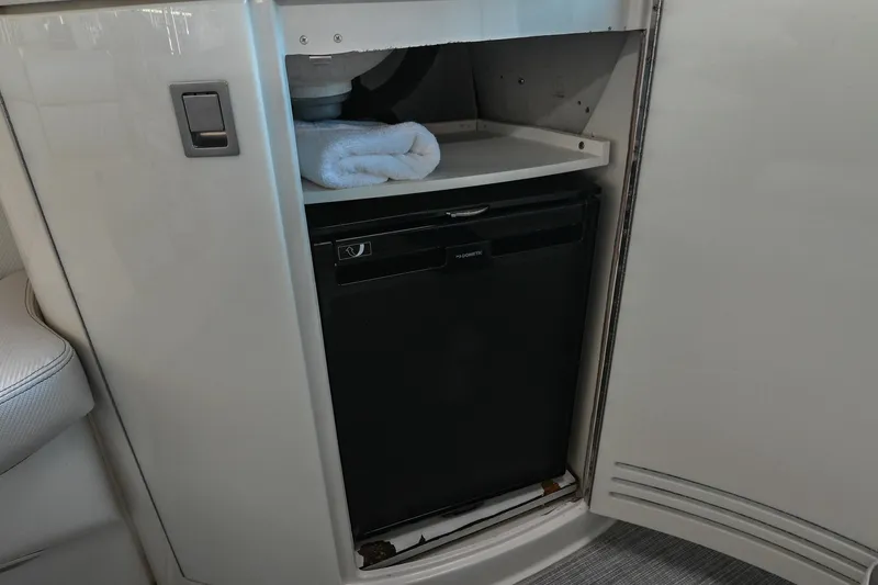 Slide: The Image of Compact refrigerator inside 2004 Cobalt 360 boat cabinet with towel on shelf. - 41