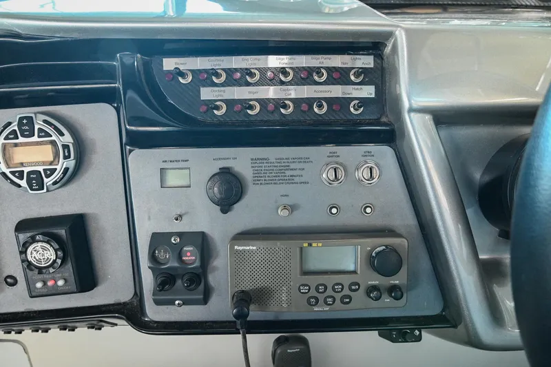 Slide: The Image of Control panel of a 2004 Cobalt 360 boat with various switches and a radio system. - 49