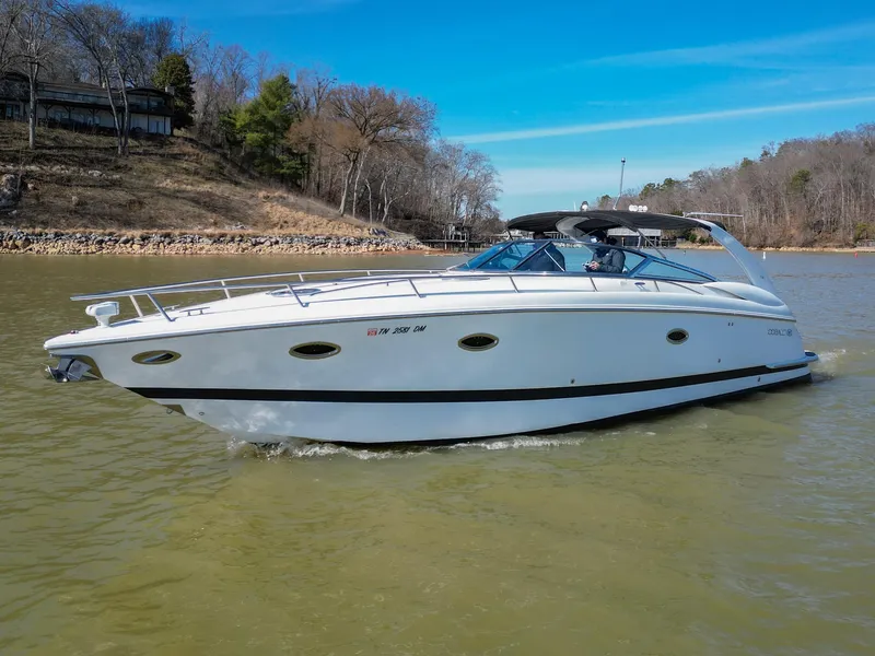 Slide: The Image of 2004 Cobalt 360 boat cruising on a lake with scenic wooded shoreline. - 8