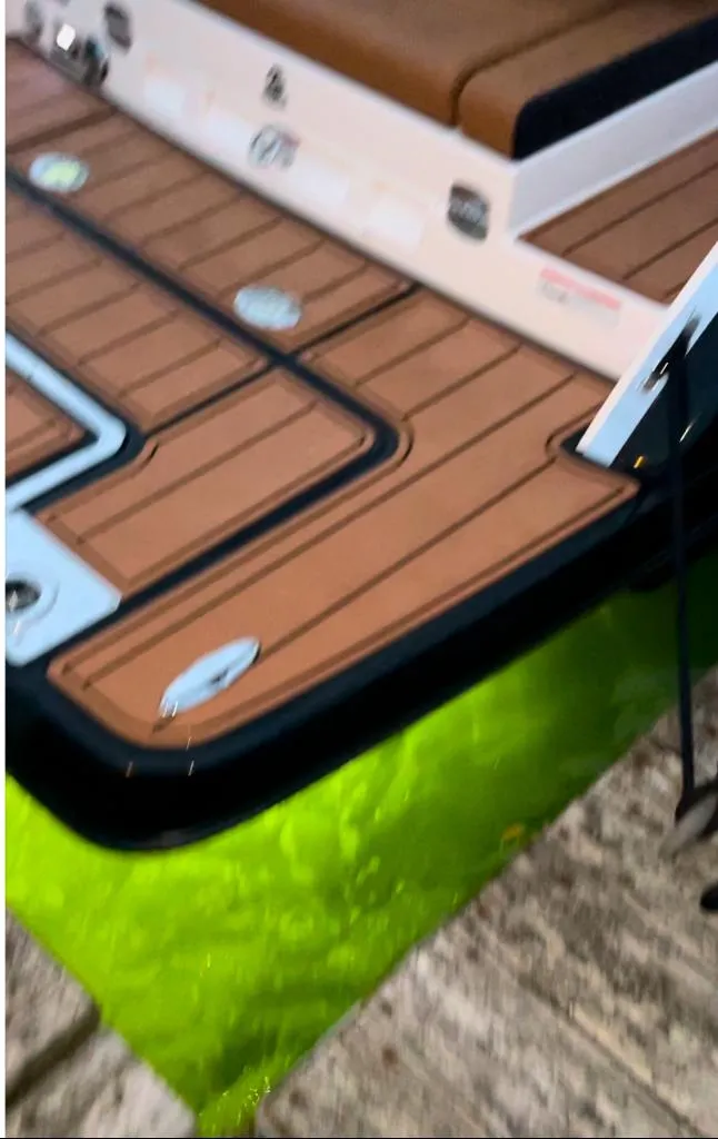 Slide: The Image of 2021 Chaparral 267 SSX boat with teak deck and vibrant underwater lighting. - 2