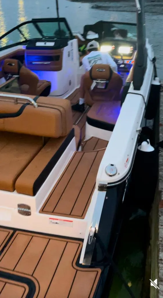 Slide: The Image of 2021 Chaparral 267 SSX boat with luxurious seating and modern dashboard, docked by the water. - 3