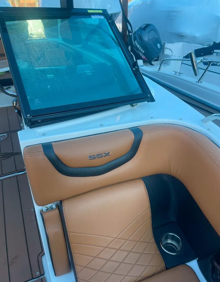 Slide: The Image of 2021 Chaparral 267 SSX boat interior with tan leather seating and cup holder. - 5