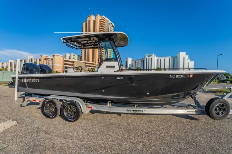 Slide: The Image of 2019 Everglades 273 CC boat on trailer, urban background, clear sky. - 10