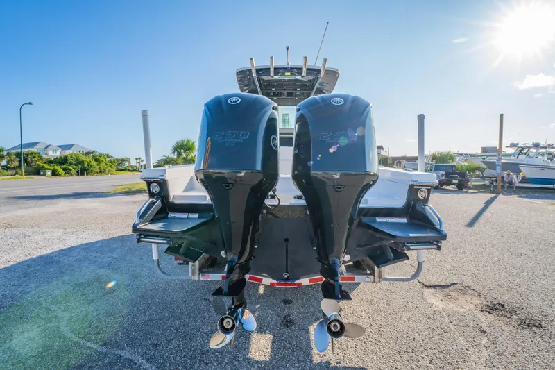 Slide: The Image of 2019 Everglades 273CC boat on trailer, parked near palm trees and shops. - 14