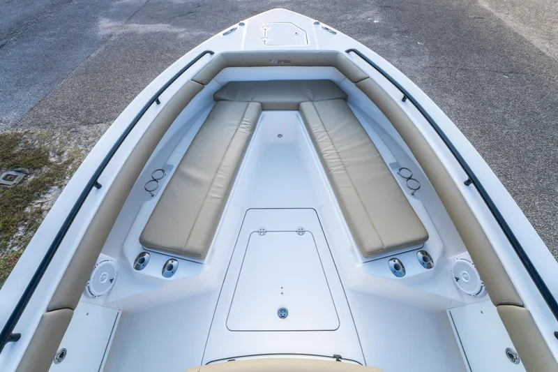 Slide: The Image of 2019 Everglades 273CC boat interior with seating and storage, docked near a road. - 25