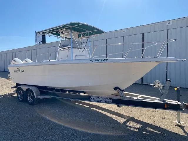 Slide: The Image of 1997 Pro-Line 240 Center Console boat on trailer, parked outdoors. - 2
