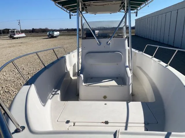 Slide: The Image of 1997 Pro-Line 240 Center Console boat with open deck and seating, parked outdoors. - 8